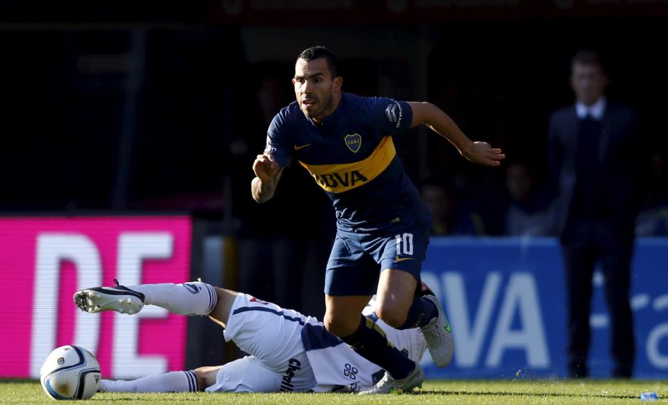 Boca Juniors&#39; Carlos Tevez runs for the ball as team coach Rodolfo Arruabarrena (R, back) watches, during their Argentine First Division soccer match against Quilmes in Buenos Aires July 18, 2015. Tevez was officially unveiled on July 13 in a 6.5 million euros ($7.15 million) transfer from Juventus. Thousands of fans of the popular club from the port district of La Boca packed La Bombonera stadium to welcome Tevez home from a decade abroad the day after the team went top of the Argentine league championship.   REUTERS/Marcos Brindicci      TPX IMAGES OF THE DAY