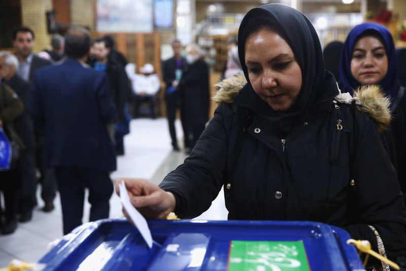 An Iranian woman casts her vote during parliamentary elections at a polling station in Tehran