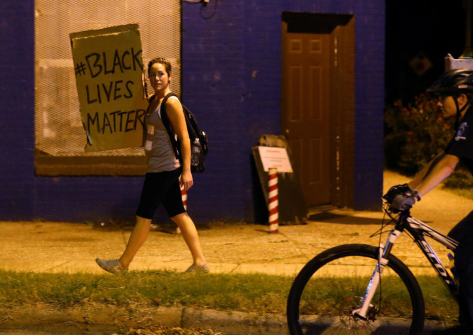 <p>A demonstrator protesting the police shooting of Keith Scott is followed by a police officer on a bike as she marches through the streets of Charlotte, N.C., on Sept. 25, 2016. (Mike Blake/Reuters)</p>