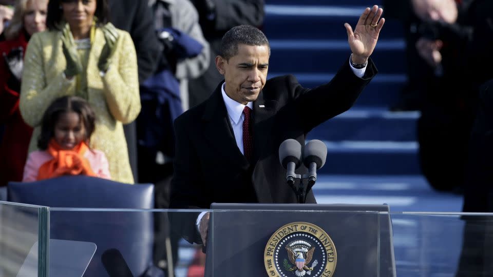 Former President Barack Obama waves after finishing his first inaugural address in 2009. He took office at a time of national peril: The Great Recession had devastated the economy and the US was embroiled in two wars. - Alex Wong/Getty Images
