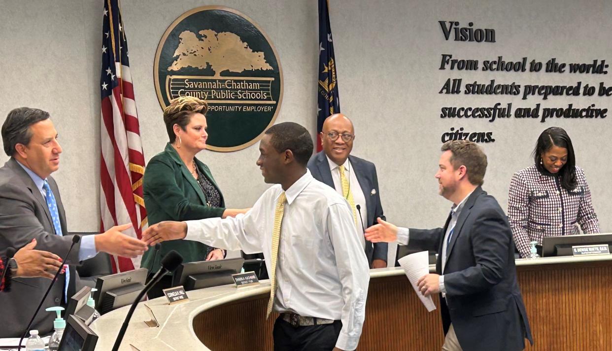 SCCPSS School Board President Roger Moss and board member Shawn Kachmar congratulate Woodville-Tompkins High School student, Jimmy Slack and his teacher John Cook during the Jan. 2024 board meeting for the school's 3rd consecutive Georgia Stock Market Game win.