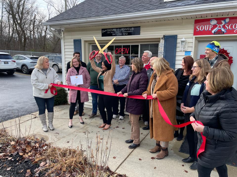 Susie Ansara prepares to cut a ribbon to celebrate the grand opening of Susie's Gems and Jewels in Green Oak Township.