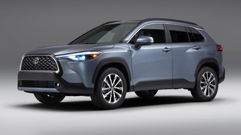 A blue-gray Toyota Corolla Cross in a white studio