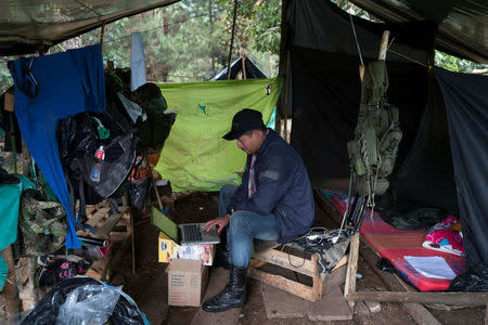Enover, the second commander of the front, works on his computer inside his makeshift tent in Los Robles, Colombia, January 26, 2017. REUTERS/Federico Rios