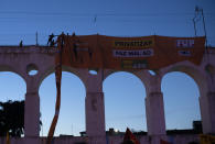 Oil workers hang a banner that reads in Portuguese "Privatizing hurts Petrobras" during a protest against layoffs at the oil giant Petrobras, in Rio de Janeiro, Brazil, Tuesday, Feb. 18, 2020. Brazilian oil workers and Petrobras were locked in a power struggle Tuesday over the company's privatization plans, with the union saying thousands of employees are on an indefinite strike. (AP Photo/Silvia Izquierdo)