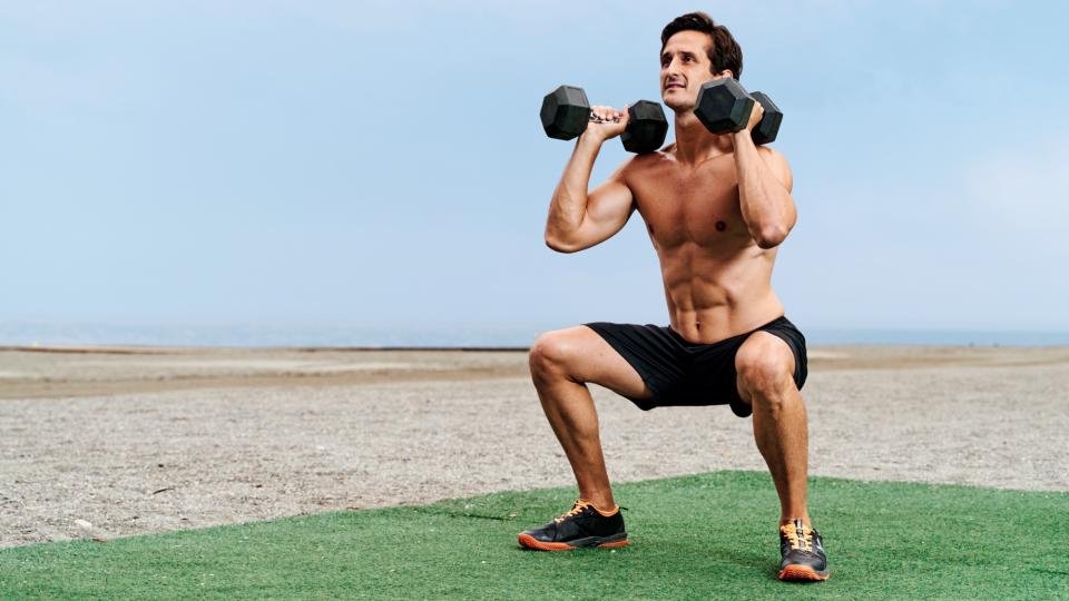 Man doing a squat with two dumbbells