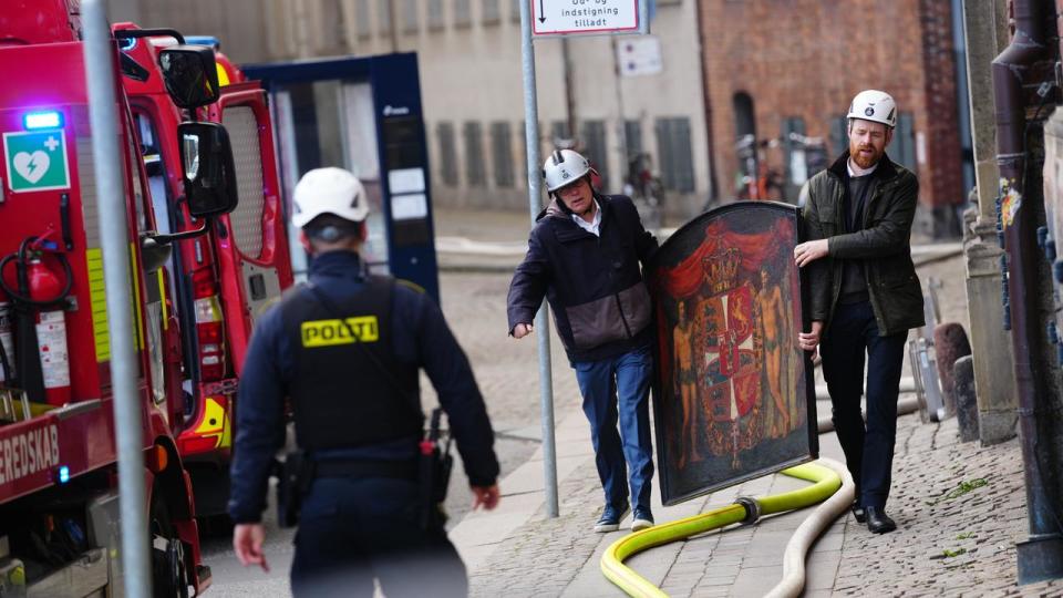 Locals carry a painting from the old Stock Exchange