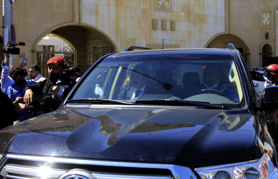 Defense lawyer Mohammad Afeef, who represents Bassem Awadallah, is driven from a State Security Court, where the trial of Awadallah, a former royal adviser, and Sharif Hassan bin Zaid, a distant cousin of the king, is taking place, in Amman, Jordan, Monday, June 21, 2021. The defendants are accused of conspiring with a senior royal — Prince Hamzah, a half-brother of the king — to foment unrest against the monarch while soliciting foreign help. Both pleaded not guilty. (AP Photo/Raad Adayleh)