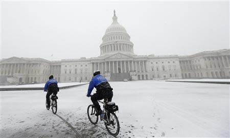 Police on mountain bikes patrol in the snow in front of the U.S. Capitol in Washington January 21, 2014. REUTERS/Kevin Lamarque