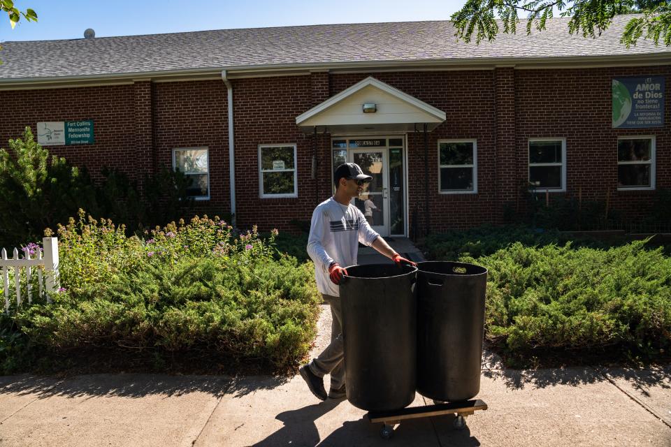Alec Zaidi empties trash cans outside the Fort Collins Mennonite Fellowship in downtown Fort Collins on Aug. 31, 2023. The church purchased and maintains the trash receptacles to prevent the property from becoming messy.