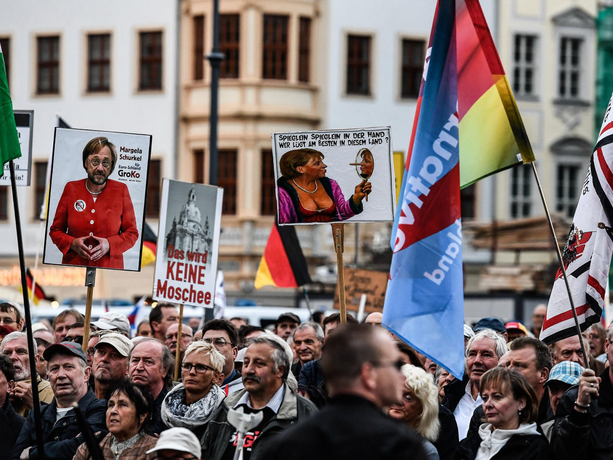 Supporters of the 'Pegida' movement and German right-wing populist party Alternative für Germany (AfD) hold banners at a rally in Dresden: EPA