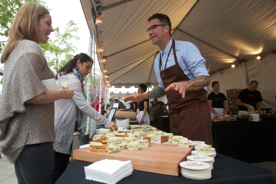 In this Sept. 20, 2012 photo, Jason French of the Ned Ludd restaurant serves shrimp and watercress tea sandwiches during the Feast Portland food festival in Portland, Ore. Far from the expectant gaze of major restaurant critics and the accompanying pressure to produce the Next Big Thing, the little-big city of Portland offers chefs a unique opportunity - the chance to experiment. (AP Photo/The Oregonian, Doug Beghtel)