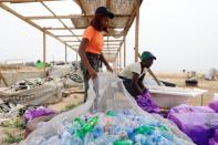 An Environmentalist, Doyinsola Ogunye holds a net filled with P.E.T bottles picked from the shore at the beach in Lagos, Nigeria