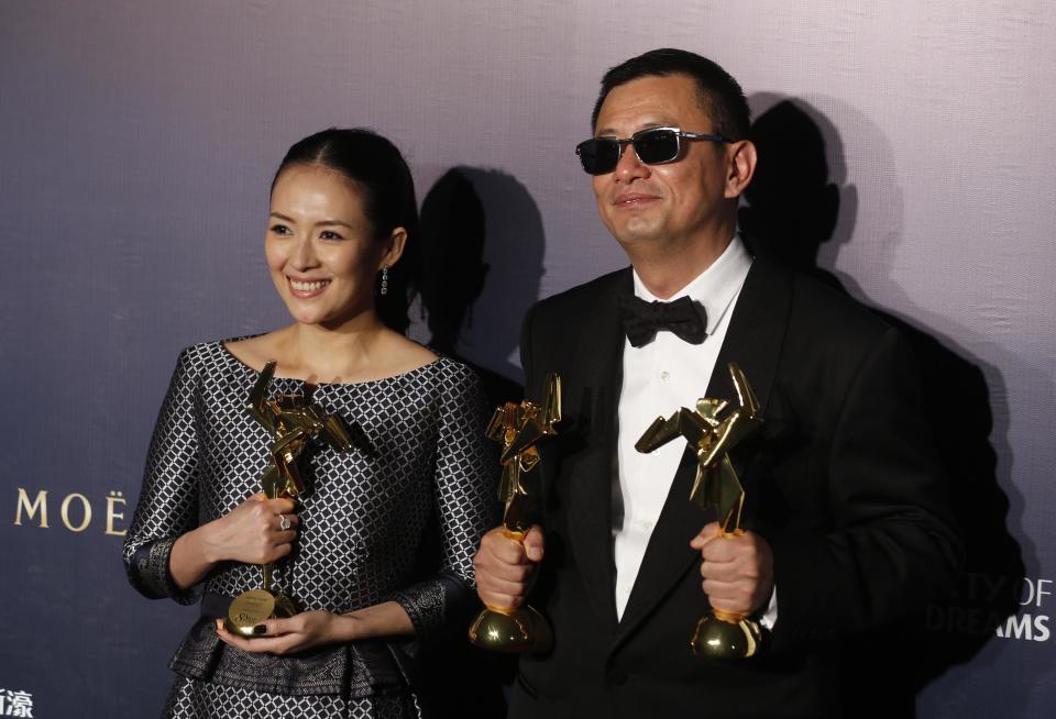 Hong Kong director Wong Kar-wai, right, and Chinese actress Zhang Ziyi pose after winning the Best Director, the Best Movie and the Best Actress for their movie "The Grandmaster," of the Asian Film Awards in Macau Thursday, March 27, 2014. (AP Photo/Kin Cheung)