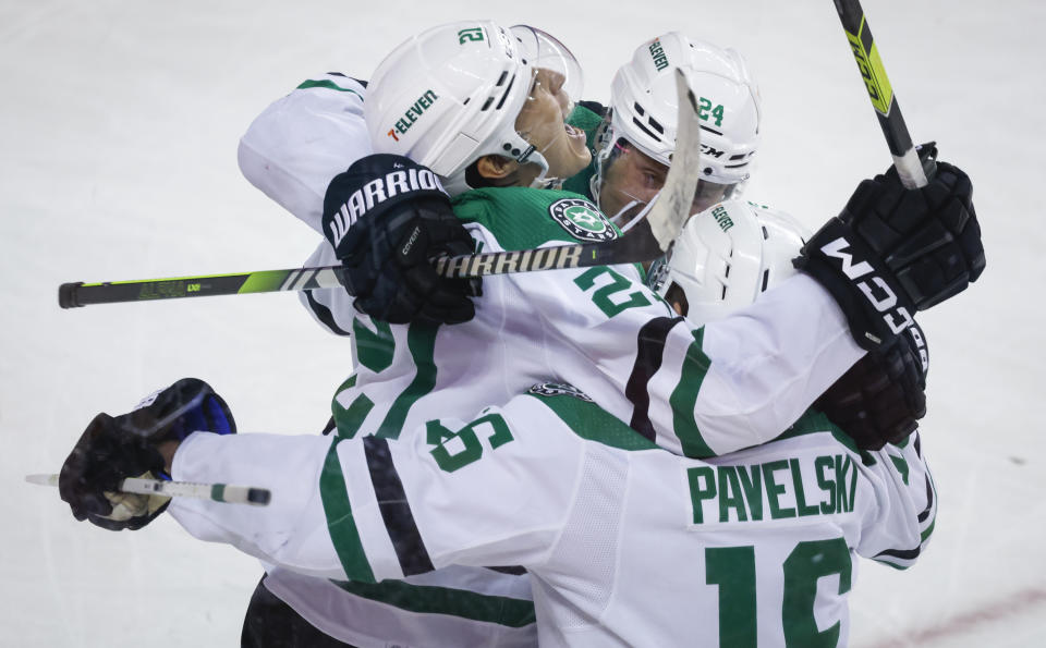 Dallas Stars forward Jason Robertson, left, celebrates his overtime goal against the Calgary Flames with teammates in an NHL hockey game Saturday, March 18. 2023, in Calgary, Alberta. (Jeff McIntosh/The Canadian Press via AP)