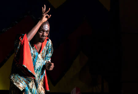 A storyteller gestures with his fingers splayed above his head as he tells the modern fable about why chickens don't fly, as the Re-imagined Storytelling Festival in Nairobi, Kenya December 15, 2018. REUTERS/Hereward Holland