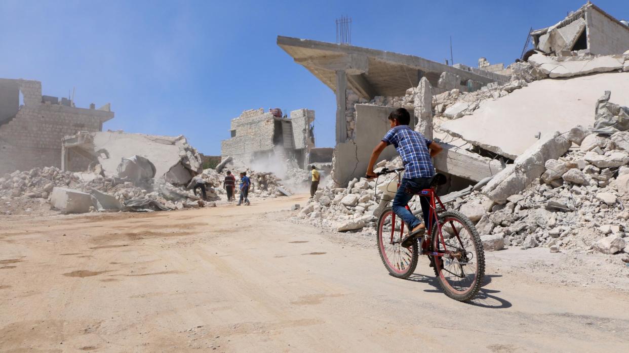 A boy rides his bicycle in the Syrian ebel-held town of Orum al-Kubra in northern Aleppo province near Idlib on 11 August 2018: AFP/Getty Images