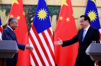 Malaysia's Prime Minister Mahathir Mohamad (L) shakes hands with China's Premier Li Keqiang at the end of a news conference at the Great Hall of the People in Beijing, China, August, 20, 2018. How Hwee Young/Pool via REUTERS