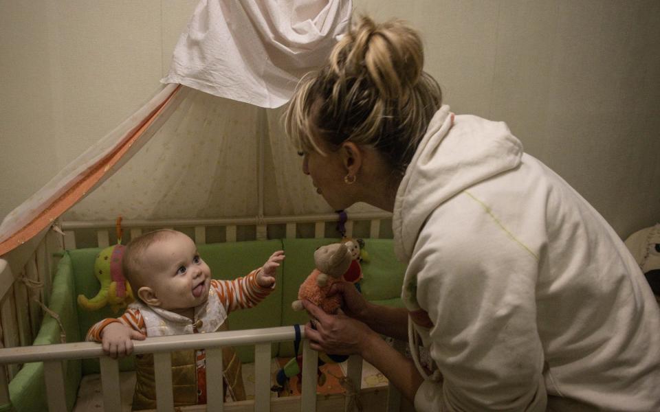 Nurse Tetiana Pavelko plays with her adopted daughter Kira at home in Ukraine. Kira was given up by her birth mother and taken to Kherson Children's Hospital where she stayed with other children from a local orphanage and was protected by Tetiana and other staff from Russian forces wanting to take the babies - Getty Images Europe