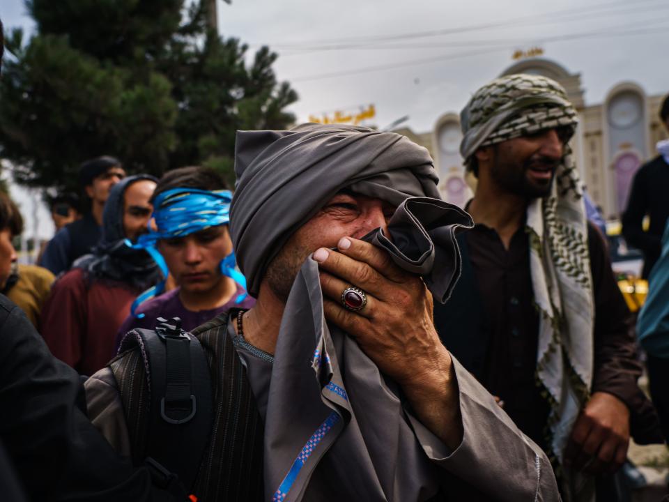 A man cries as he watches fellow Afghans get wounded by Taliban fighters