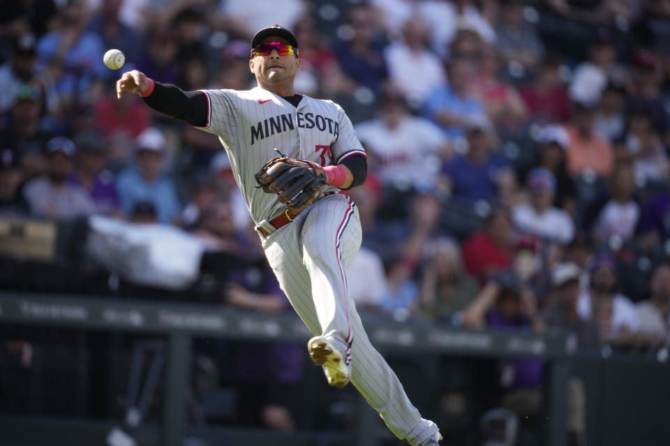 Minnesota Twins third baseman Donovan Solano throws to first base after fielding a bunt single off the bat of Colorado Rockies' Brenton Doyle in the sixth inning of a baseball game ,Sunday, Oct. 1, 2023, in Denver. (AP Photo/David Zalubowski)