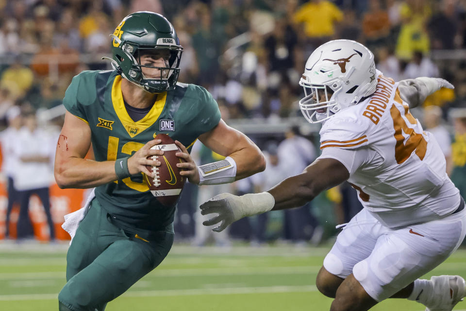 Baylor quarterback Sawyer Robertson (13) avoids Texas defensive lineman Vernon Broughton (45) during the second half of an NCAA college football game Saturday, Sept. 23, 2023, in Waco, Texas. (AP Photo/Gareth Patterson)