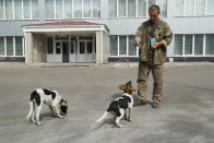 <p>Sergey Shamray, a worker at the Chernobyl nuclear power plant, tosses pieces of bread to stray dogs outside the workers cafeteria inside the exclusion zone at the Chernobyl plant on Aug. 18, 2017, near Chernobyl, Ukraine. (Photo: Sean Gallup/Getty Images) </p>