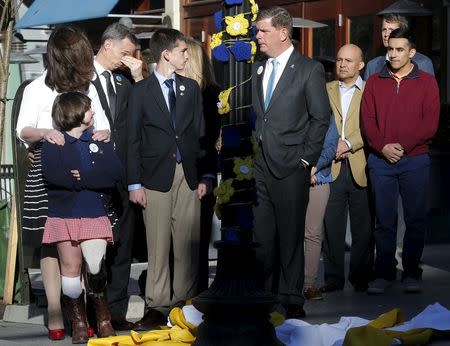 The family of Boston Marathon bombing victim Martin Richard (L) joins Boston Mayor Marty Walsh (C) at a ceremony at the site of the second bomb blast on the second anniversary of the bombings in Boston, Massachusetts April 15, 2015. REUTERS/Brian Snyder