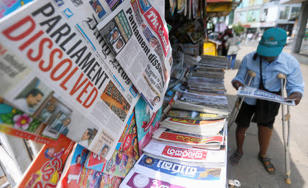 A man reads a newspaper at stall carrying the news of the Sri Lanka's parliament being dissolved, on a main road in Colombo, Sri Lanka November 10, 2018.REUTERS/Dinuka Liyanawatte