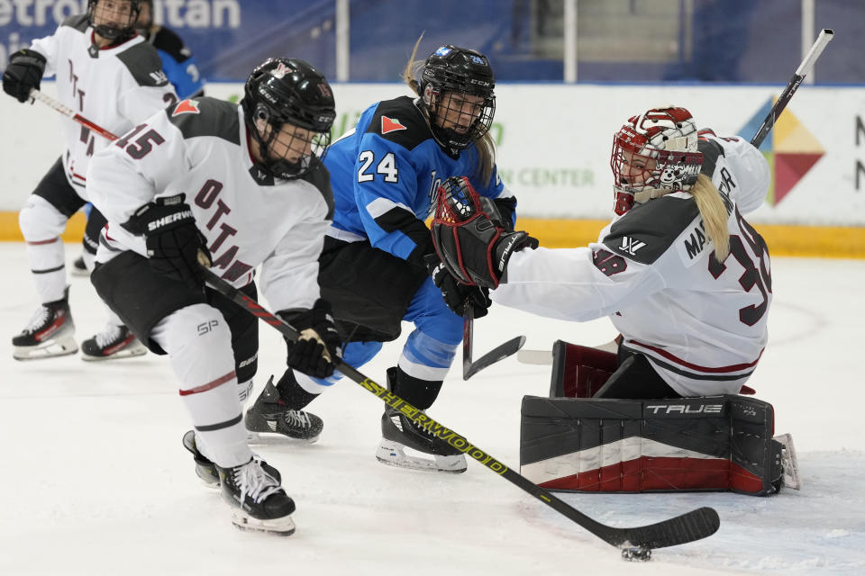 Ottawa goalie Emerance Maschmeyer, right, and Toronto's Natalie Spooner (24) look on as Ottawa's Savannah Harmon, front left, clears the puck during second-period PWHL hockey game action in Toronto, Sunday, May 5, 2024. (Frank Gunn/The Canadian Press via AP)