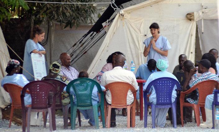 Health workers speak to relatives of people infected with Ebola at an isolation center at Donka Hospital in Conakry on April 14, 2014 (AFP Photo/Cellou Binani)