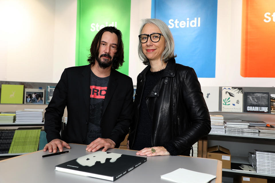 A photo of Alexandra Grant and Keanu Reeves posing with their book, Ode to happiness, in 2017 in Paris