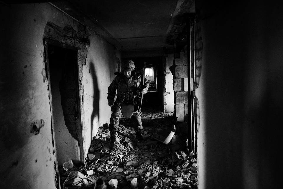 <p>A Ukrainian soldier advances to his position within a damaged hospital in Marynka, Ukraine, April 2017. (Photo: Manu Brabo/MeMo) </p>