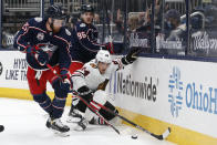 Chicago Blackhawks' Pius Suter, right, tries to clear the puck away from Columbus Blue Jackets' Mikhail Grigorenko, left, and Jack Roslovic during the second period of an NHL hockey game Saturday, April 10, 2021, in Columbus, Ohio. (AP Photo/Jay LaPrete)