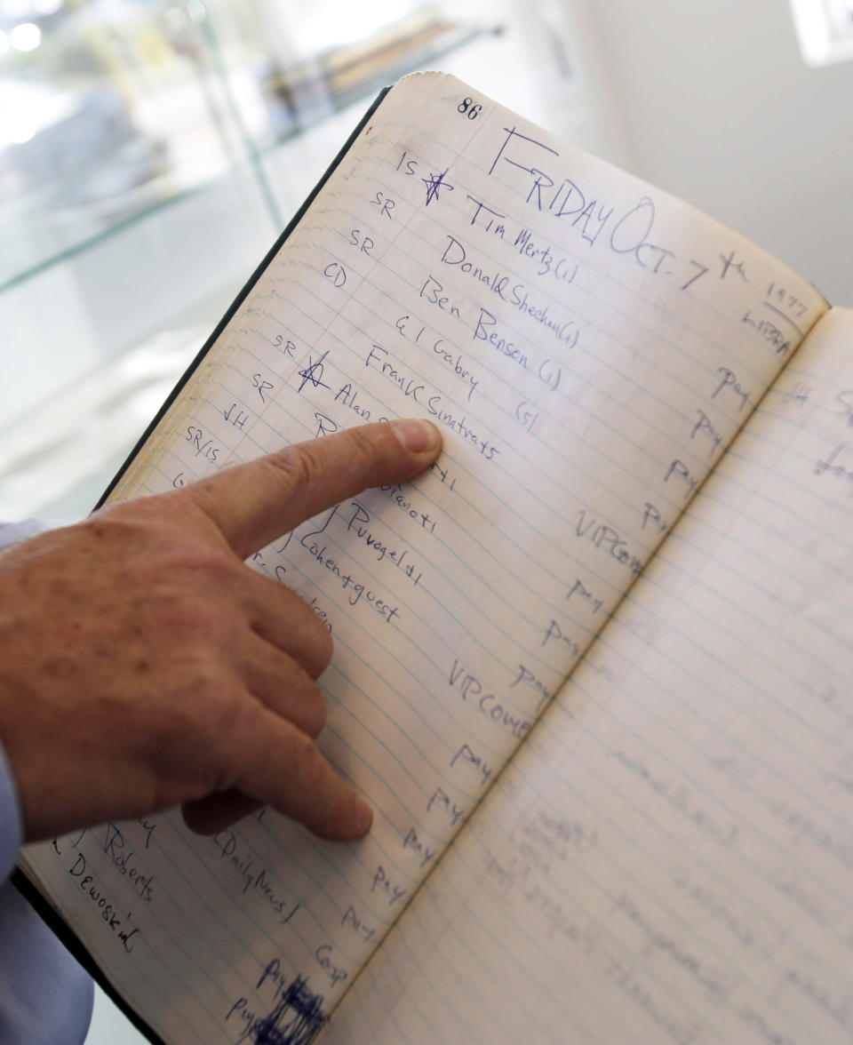 This Jan. 16, 2013 photo shows a finger pointing to the name Frank Sinatra in a reservation book for the famed New York Studio 54 night club in West Palm Beach, Fla. Memorabilia from the famed 1970s club is hitting the auction block in Florida. The private collection of co-founder Steve Rubell is being sold Saturday in West Palm Beach. (AP Photo/Alan Diaz)