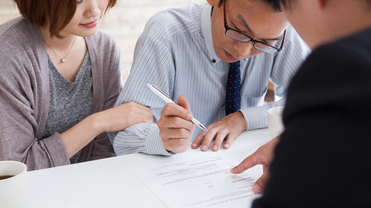 couple signing a real estate contract in real estate agency.