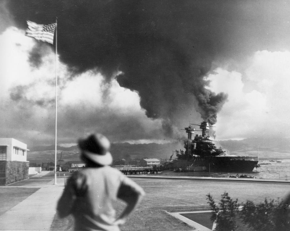 FILE - American ships burn during the Japanese attack on Pearl Harbor, Hawaii, in this Dec. 7, 1941 file photo. The coronavirus pandemic is preventing Pearl Harbor survivors from attending an annual ceremony to remember those killed in the 1941 attack. The National Park Service and Navy also are closing the ceremony to the public and livestreaming it instead. (AP Photo, File)