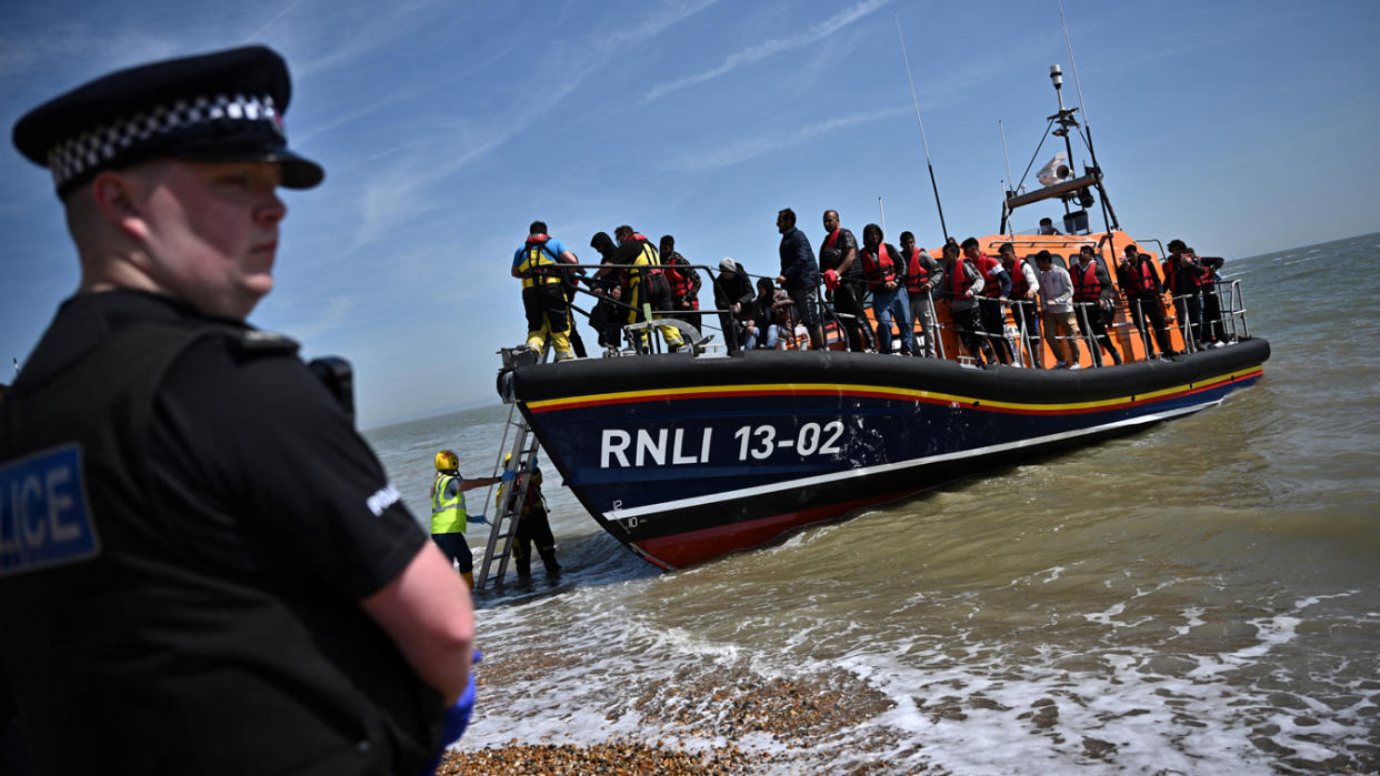 Royal National Lifeboat Institution staff help migrants disembark in Dungeness, England, after they were picked up at sea.