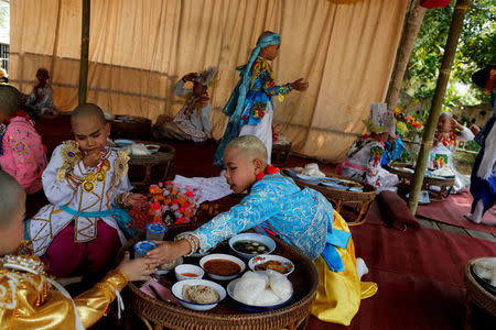 Boys have lunch after an annual Poy Sang Long procession, part of the traditional rite of passage for boys to be initiated as Buddhist novices, in Mae Hong Son, Thailand, April 3, 2018. REUTERS/Jorge Silva