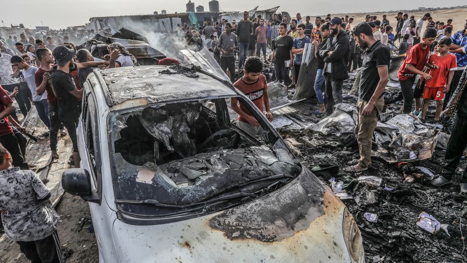 Palestinians gather around a burnt car after an Israeli airstrike on a camp in the southernmost city of Rafah, the Gaza Strip on Monday. - Abed Rahim Khatib/picture alliance/Getty Images