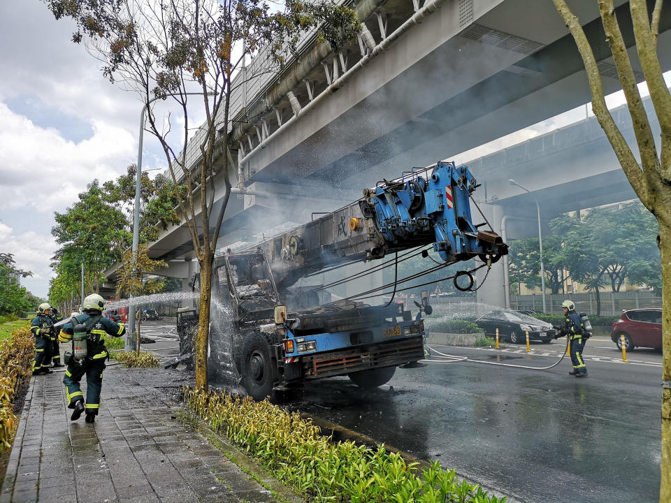 北市內湖區26日中午驚傳發生火燒車意外， 一輛有機械手臂的大型工程車故障臨停路邊，卻因不明原因自燃，警消獲報後立即趕往現場馳援，火勢迅速撲滅，幸未釀傷亡。（中央社/民眾提供） 