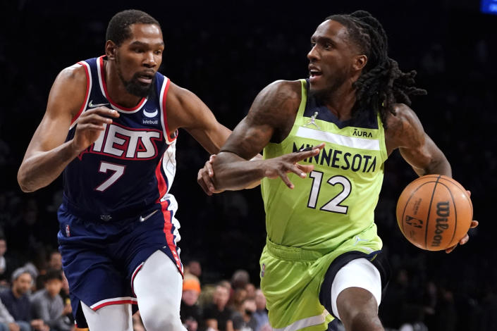 Minnesota Timberwolves forward Taurean Prince (12) drives against Brooklyn Nets forward Kevin Durant (7) during the first half of an NBA basketball game Friday, Dec. 3, 2021, in New York. (AP Photo/Mary Altaffer)