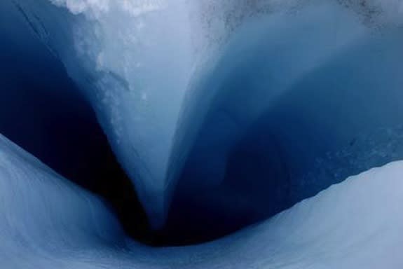 Meltwater from the surface of the Sermeq Avannarleq Glacier drains down toward interior ice (see falling droplets at right).