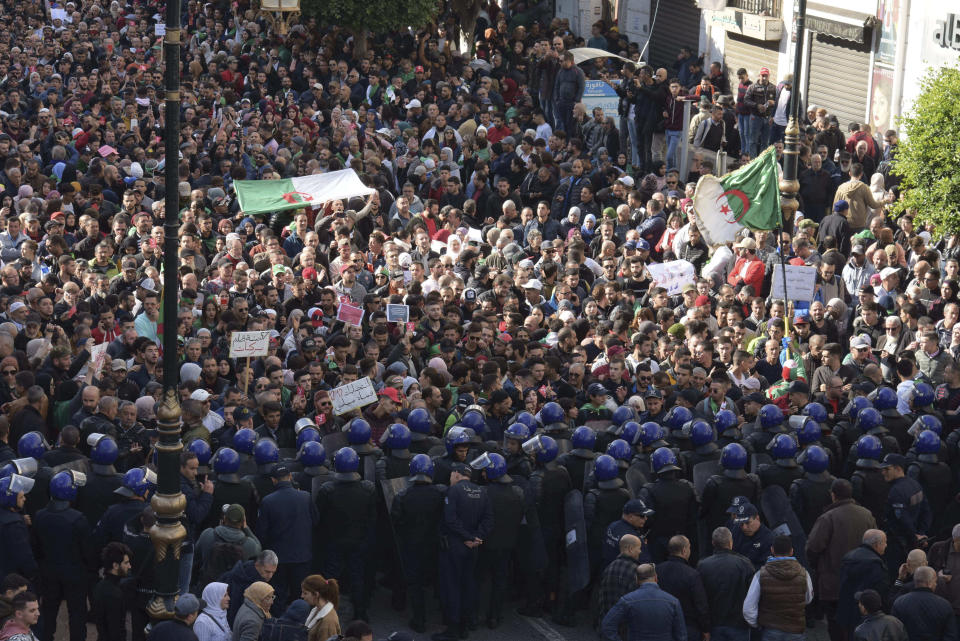 Algerian demonstrators take to the streets in the capital Algiers to protest against the government and reject the upcoming presidential elections, in Algeria, Wednesday, Dec. 11, 2019. Algeria's powerful army chief promises that a presidential election on Thursday will define the contours of a new era for a nation where the highest office has stood vacant for eight months. The tenacious pro-democracy movement which forced leader Abdelaziz Bouteflika to resign after 20 years in power doesn't trust the confident claim and is boycotting the vote. (AP Photo/Toufik Doudou)