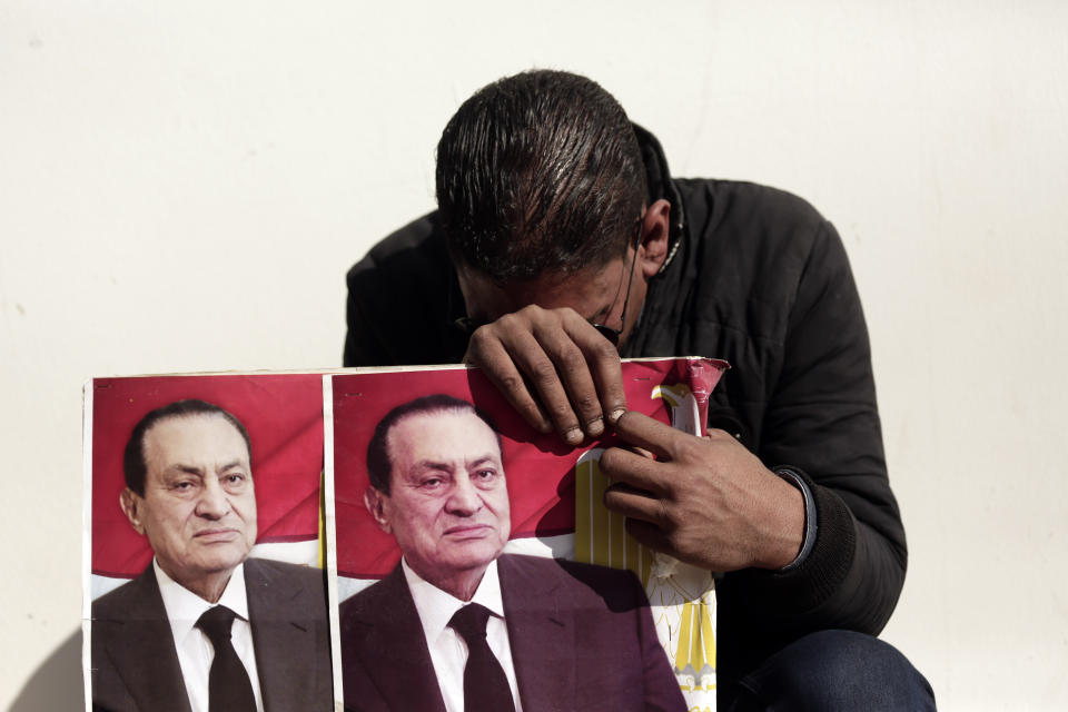 A supporter of ousted President Hosni Mubarak weeps outside of the El-Mosheer Tantawy Mosque before his funeral in Cairo, Egypt, Wednesday, Feb. 26, 2020. Egypt is holding a full-honors military funeral for Mubarak who was ousted from power in the 2011 Arab Spring uprising. Mubarak, 91, died Tuesday at a Cairo military hospital from heart and kidney complications. A few dozen Mubarak supporters, clad in black and carrying posters of the former president, gathered since morning hours at the mosque complex where Mubarak's body was brought for the funeral service. (AP Photo / Maya Alleruzzo)