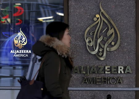 A woman passes by the Al Jazeera America broadcast center in midtown Manhattan in New York City January 13, 2016. REUTERS/Brendan McDermid