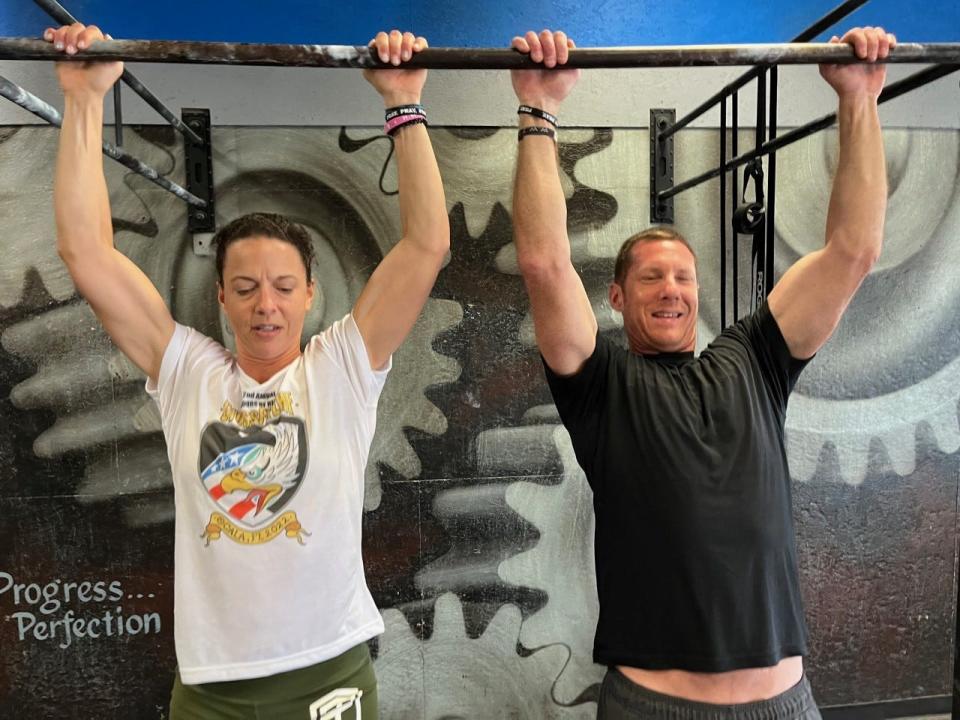 Nina Graunke and Rob Pritz do pull-up before participating in the grueling “Murph” workout set at the Zone Heath and Fitness on Memorial Day.