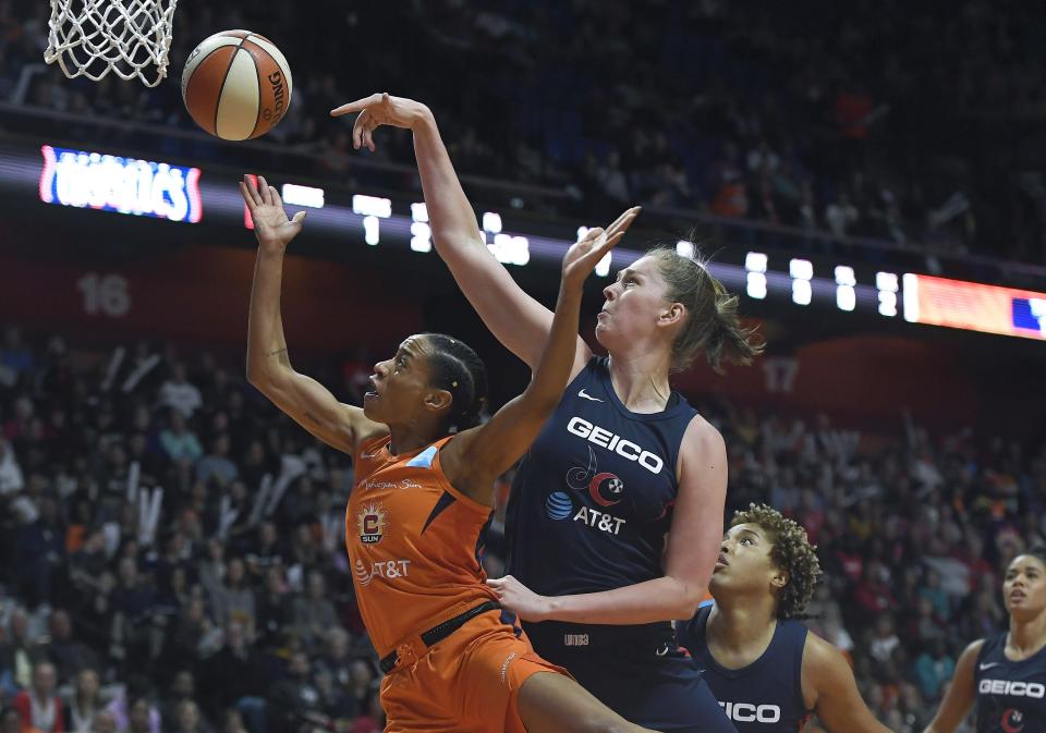 Connecticut Sun's Jasmine Thomas, left, drives to the basket against Washington Mystics' Emma Meesseman during the first half in Game 4 of basketball's WNBA Finals, Tuesday, Oct. 8, 2019, in Uncasville, Conn. (AP Photo/Jessica Hill)