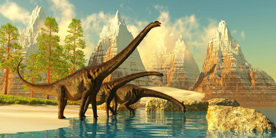An artist's rendering of three sauroposeidens, long-necked dinosaurs who walked on all fours, in a mountainous landscape by a lake.