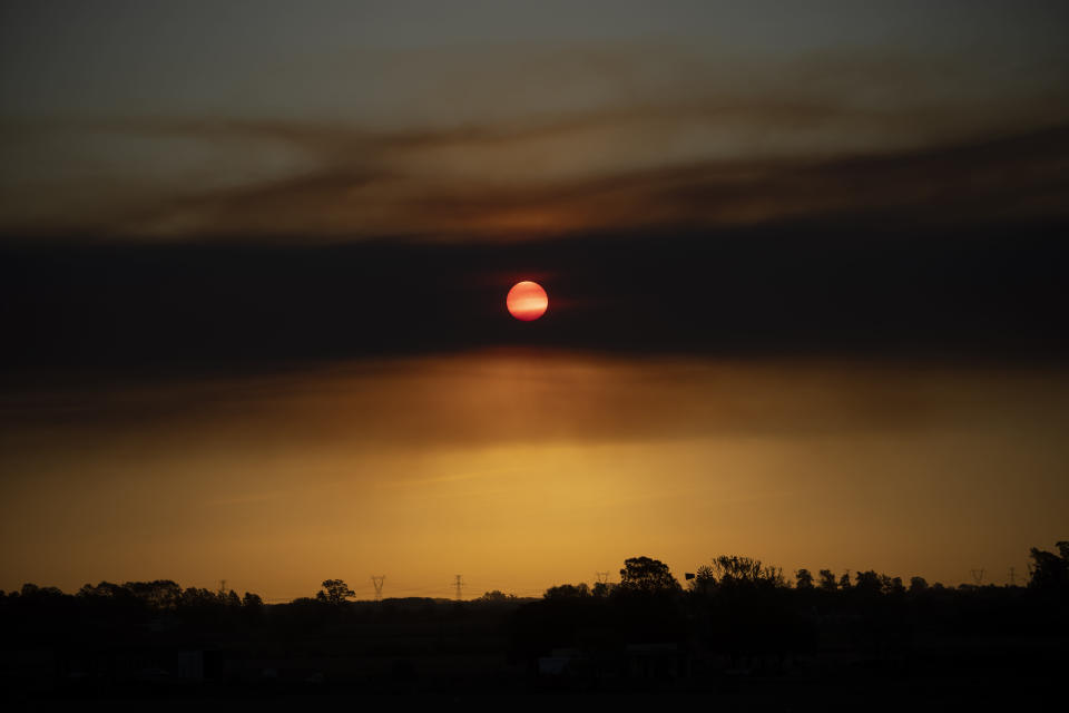 El sol se pone a través de una nube de humo de los incendios forestales cerca de Villa Constitución, Argentina, el jueves 15 de septiembre de 2022. (AP Foto/Víctor R. Caivano)